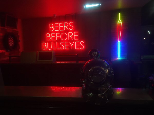 BEERS BEFORE BULLS EYES' red neon sign. Real glass neon fitted directly onto wall.
