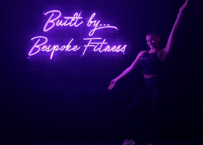 Built by Bespoke Fitness' purple neon sign. Real glass neon on a clear acrylic panel cut to shape.