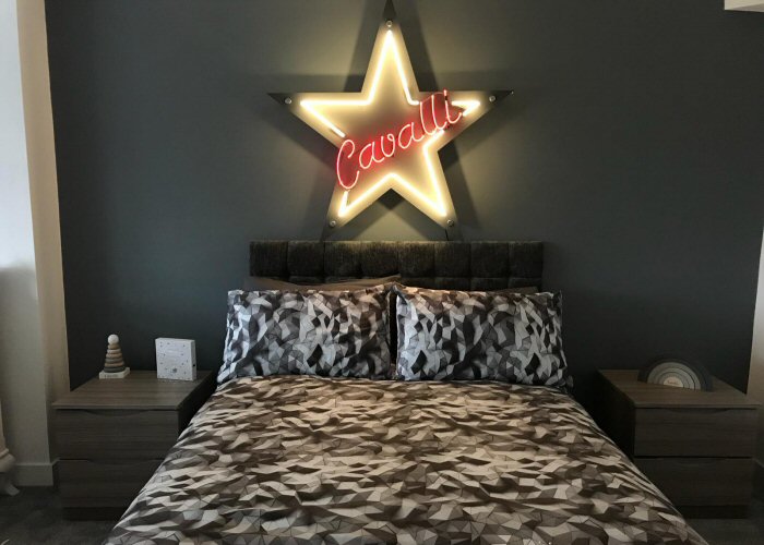 Cavalli' white and purple neon sign. Real glass neon sign mounted on to silver acrylic panel cut to shape.