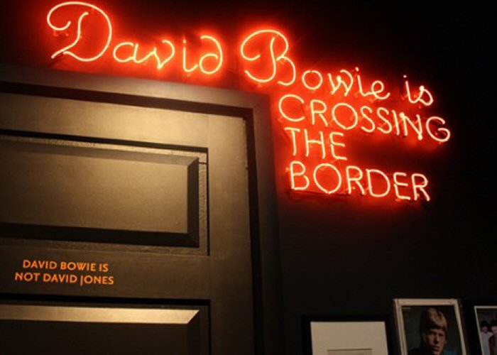 Davd Bowie IS CROSSING THE BORDER' red neon sign. Real glass neon fitted directly on to the wall.