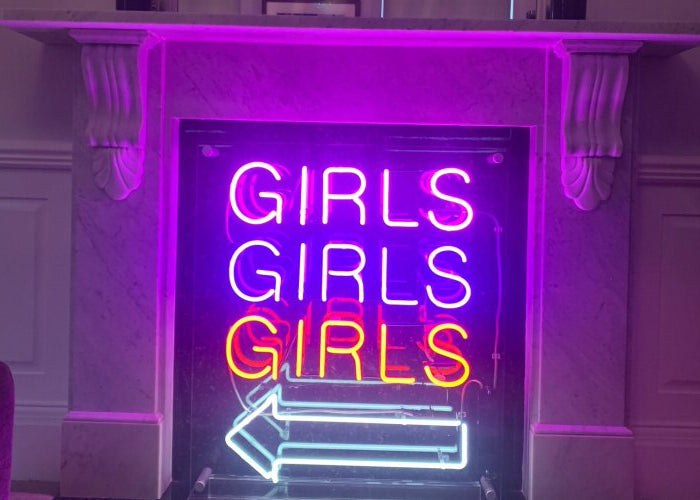 GIRLS GIRLS GIRLS' neon sign for home. Real glass neon on a free standing clear acrylic panel.