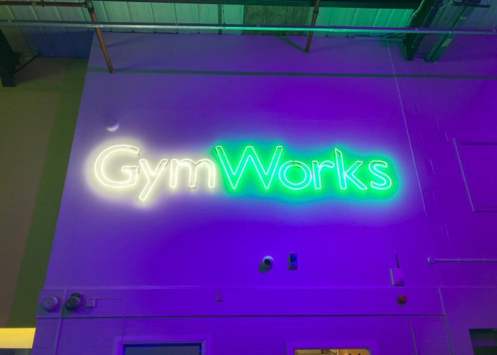 GymWorks' white and green neon sign. Real glass neon fitted directly onto the wall.