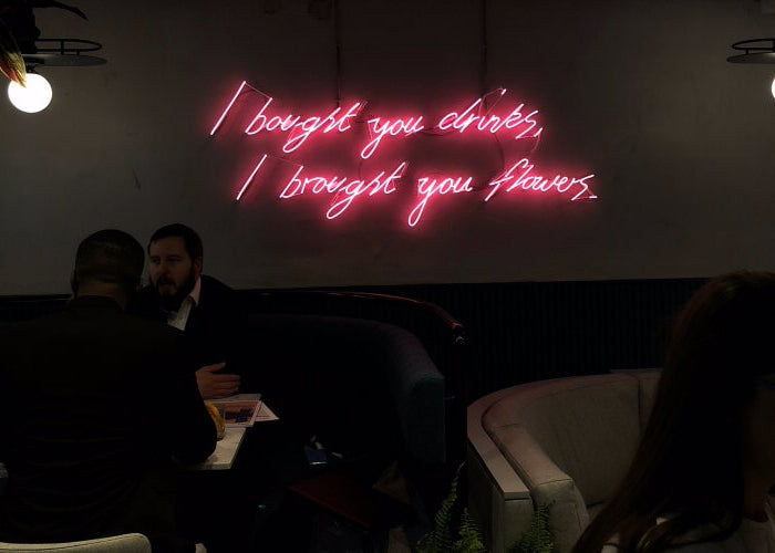 I bought you drinks, I bought you flowers.' pink neon sign. Real glass neon fitted directly onto wall.