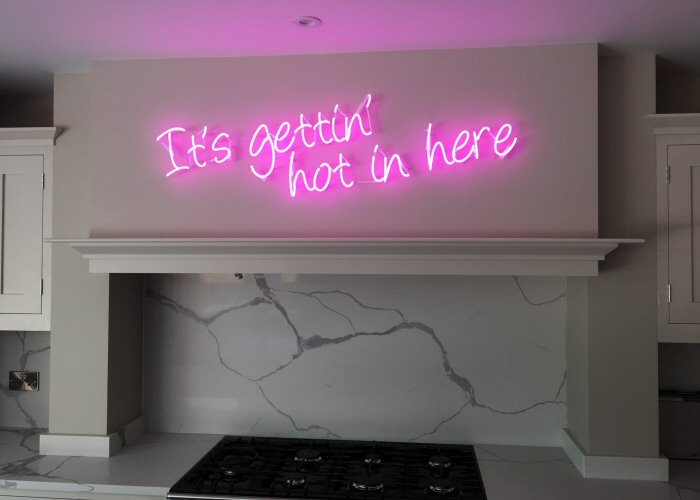 It's gettin' hot in here' pink neon sign. Real glass neon fitted directly onto wall.