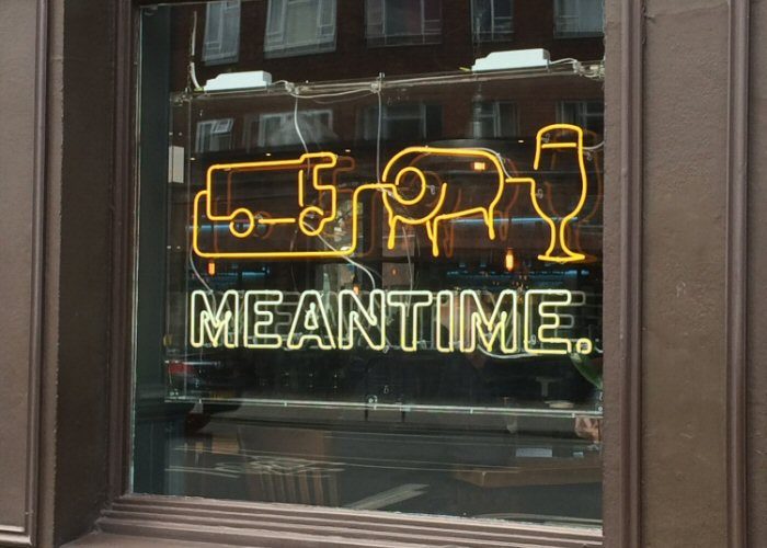 MEANTIME' yellow and white neon sign. Real glass neon fitted inside clear acrylic case.