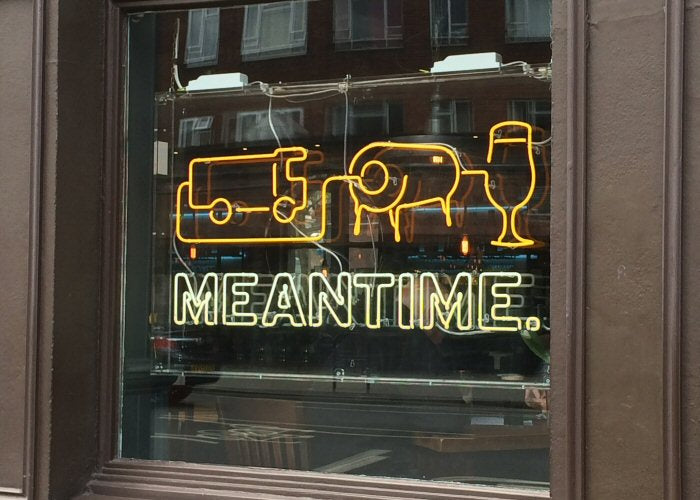 MEANTIME' yellow and white neon sign. Real glass neon fitted inside clear acrylic case.