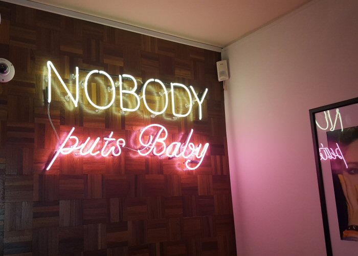 NOBODY puts baby' white and pink neon sign. Real glass neon fitted directly onto wall.