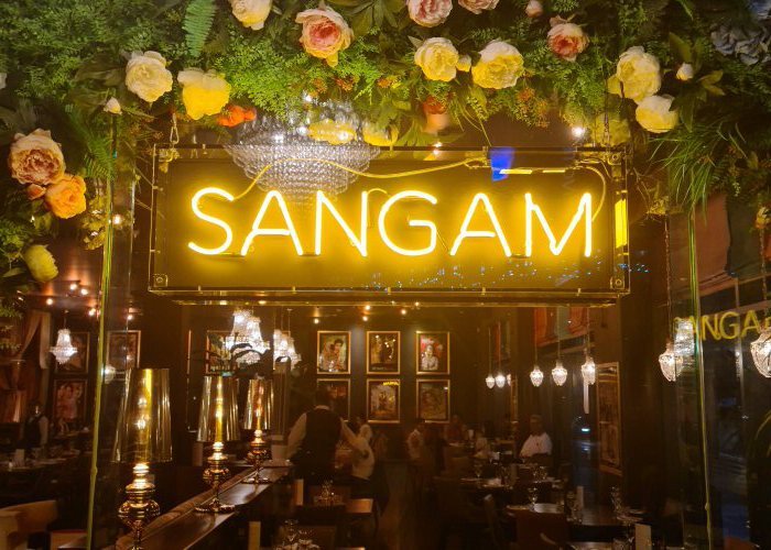 SANGAM' yellow neon sign. Real glass neon fitted inside acrylic case with black back.