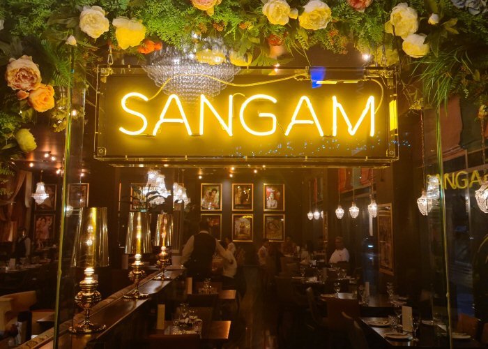 SANGAM' yellow neon sign. Real glass neon fitted inside acrylic case with black back.