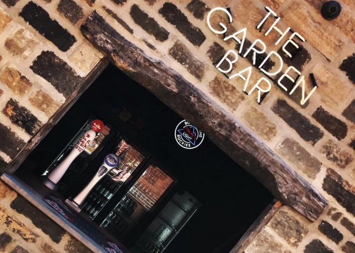 THE GARDEN BAR' white neon sign. Real glass neon fitted directly onto wall.