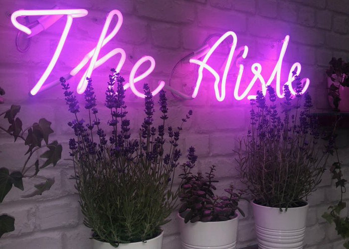 The Aisle' pink neon sign. Real glass neon fitted directly onto wall.