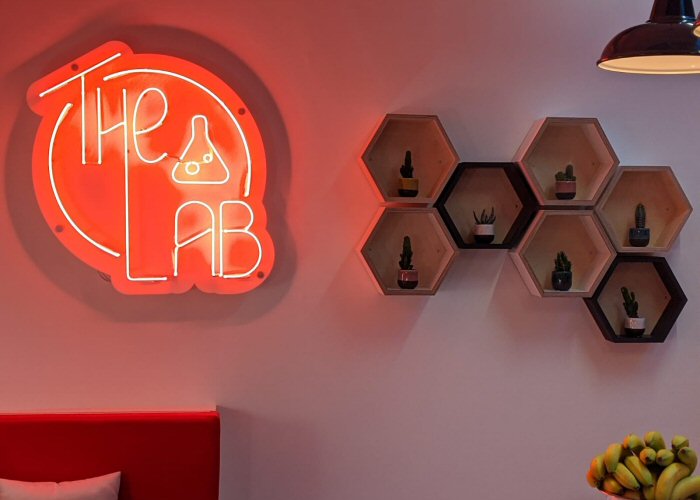 The Lab' red neon sign. Real glass neon mounted on a white acrylic panel cut to shape.