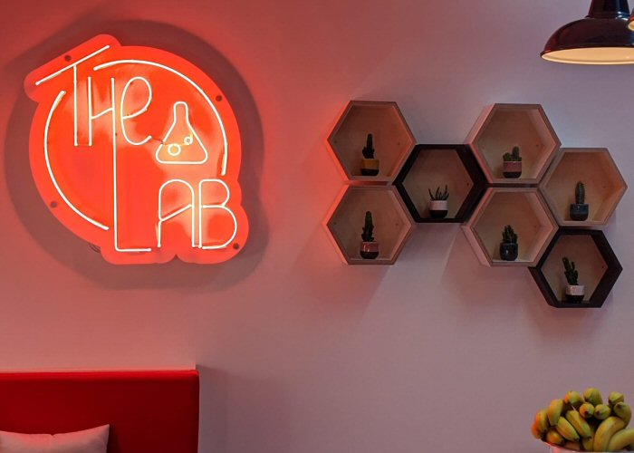 The Lab' red neon sign. Real glass neon mounted on a white acrylic panel cut to shape.