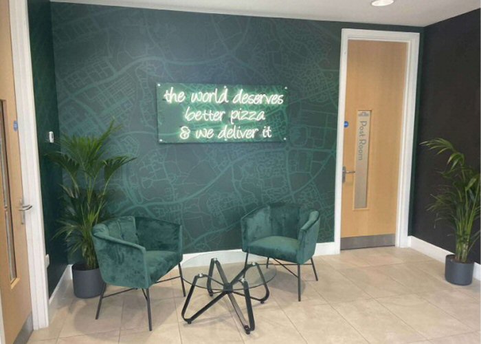 The world deserves better pizza' white neon sign. Real glass neon fitted onto printed acrylic panel.