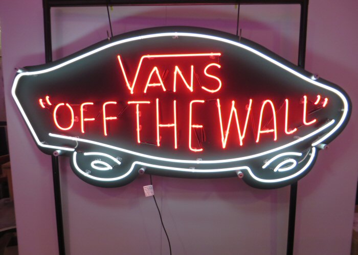 VANS OFF THE WALL' red and white neon sign. Real glass neon fitted onto black acrylic panel cut to shape.