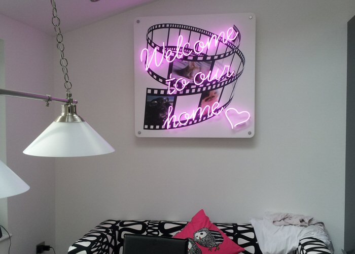 Welcome to our home' magenta neon sign. Real glass neon fitted onto white acrylic case with printed face.
