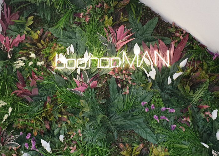boohooMAN' white neon sign. Real glass neon fitted onto artificial foliage.