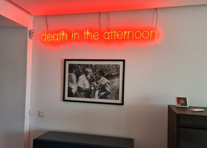 death in the afternoon' red neon sign. Real glass neon fitted directly onto wall.